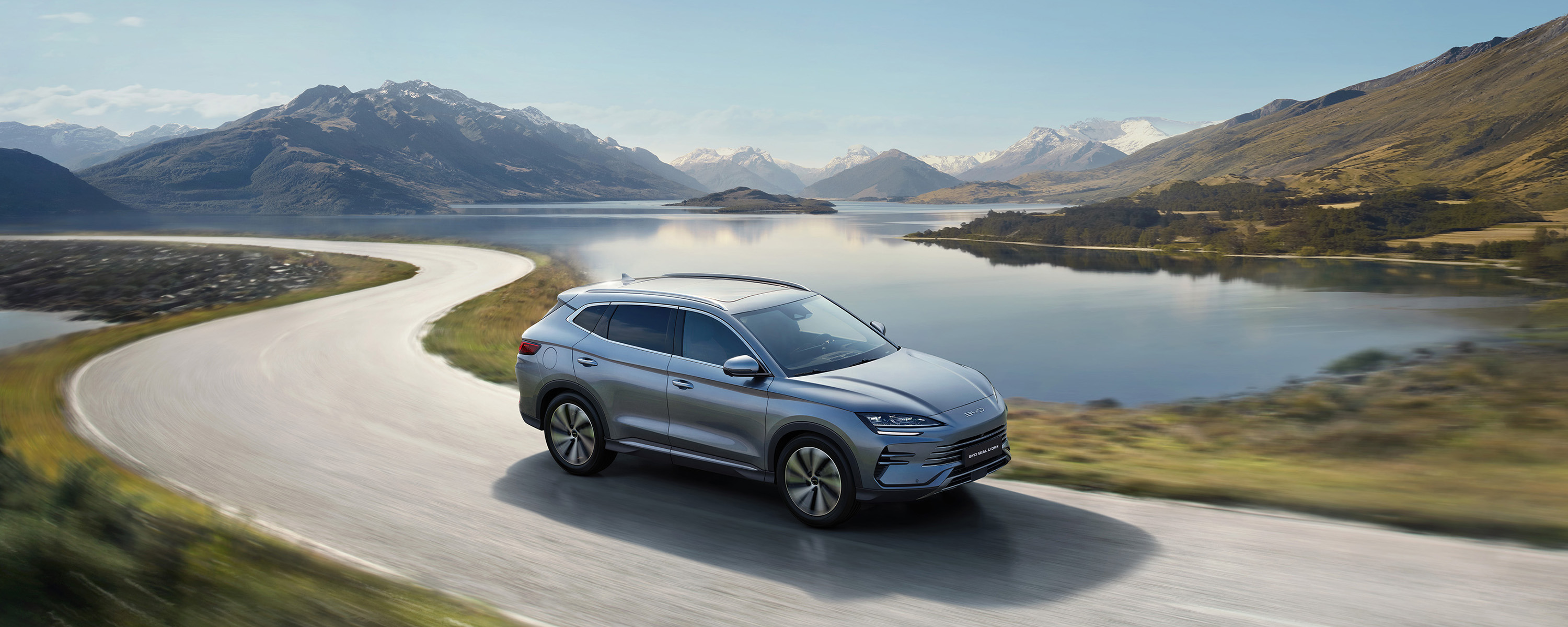 Ein grauer BYD SEAL U DM-i fährt vor einem See