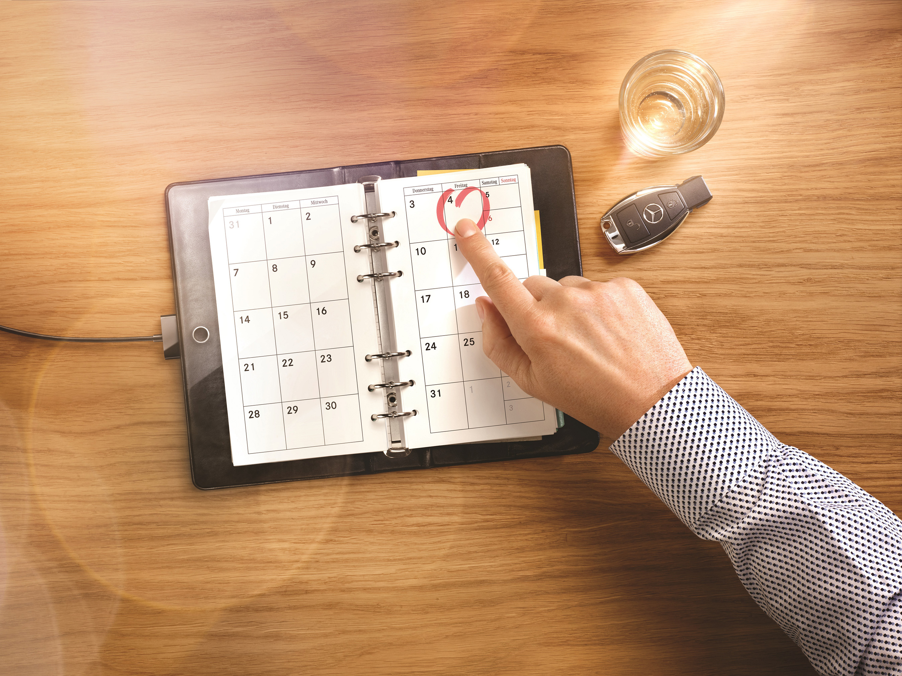 Eine Hand zeigt auf einen aufgeschlagenen Kalender