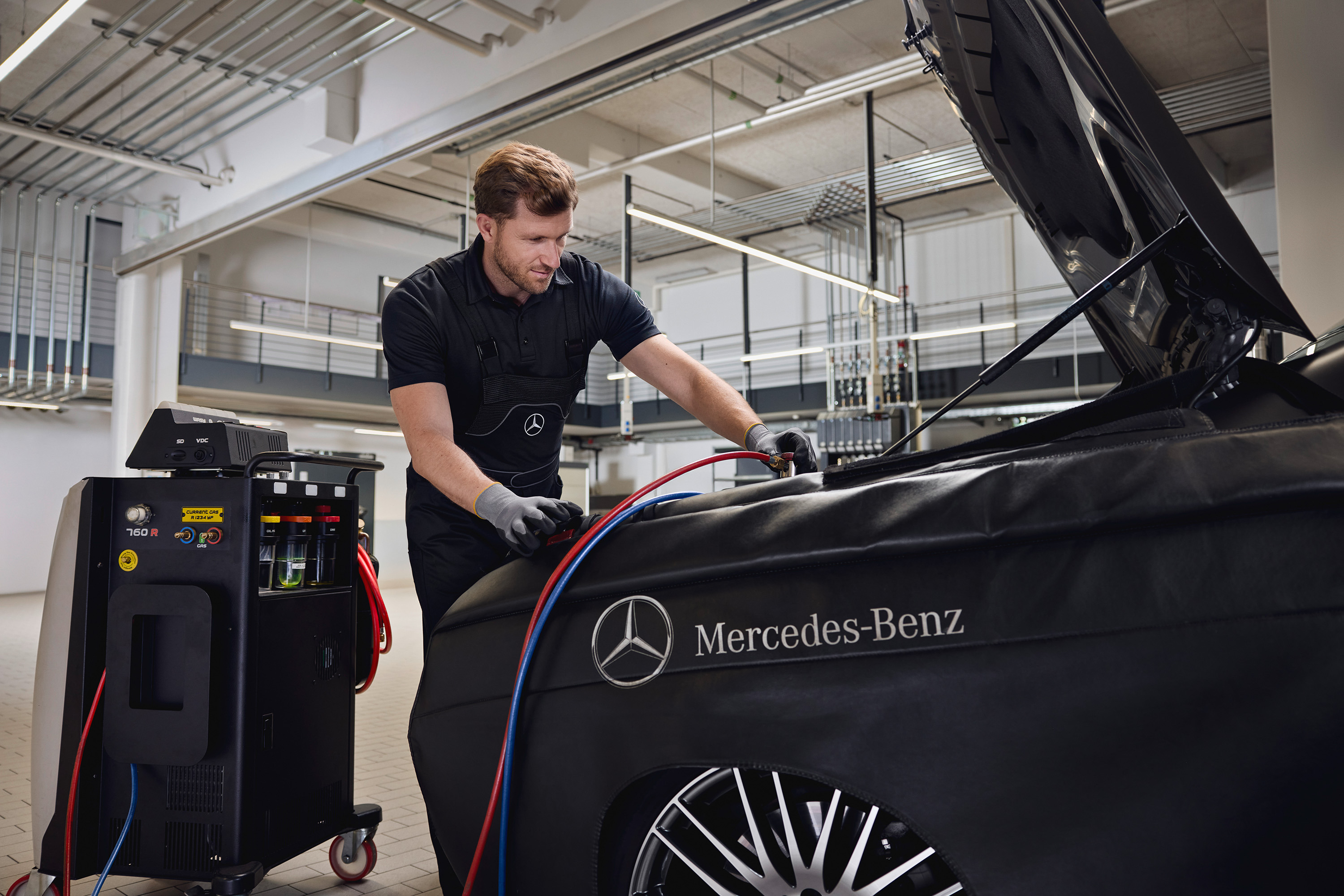 Mercedes-Benz Monteur steht vor Fahrzeug mit offener Motorhaube
